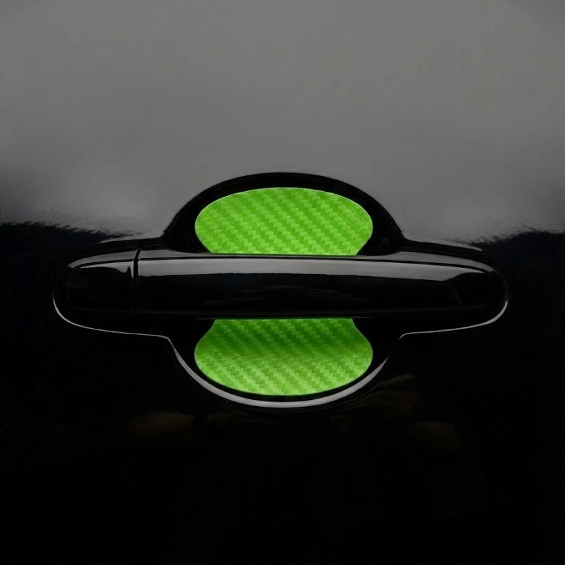 Green carbon fiber door handle scratch guard sticker installed on black car door bowl. A quirky Car-Wah! car accessory statement piece that adds instant personality.