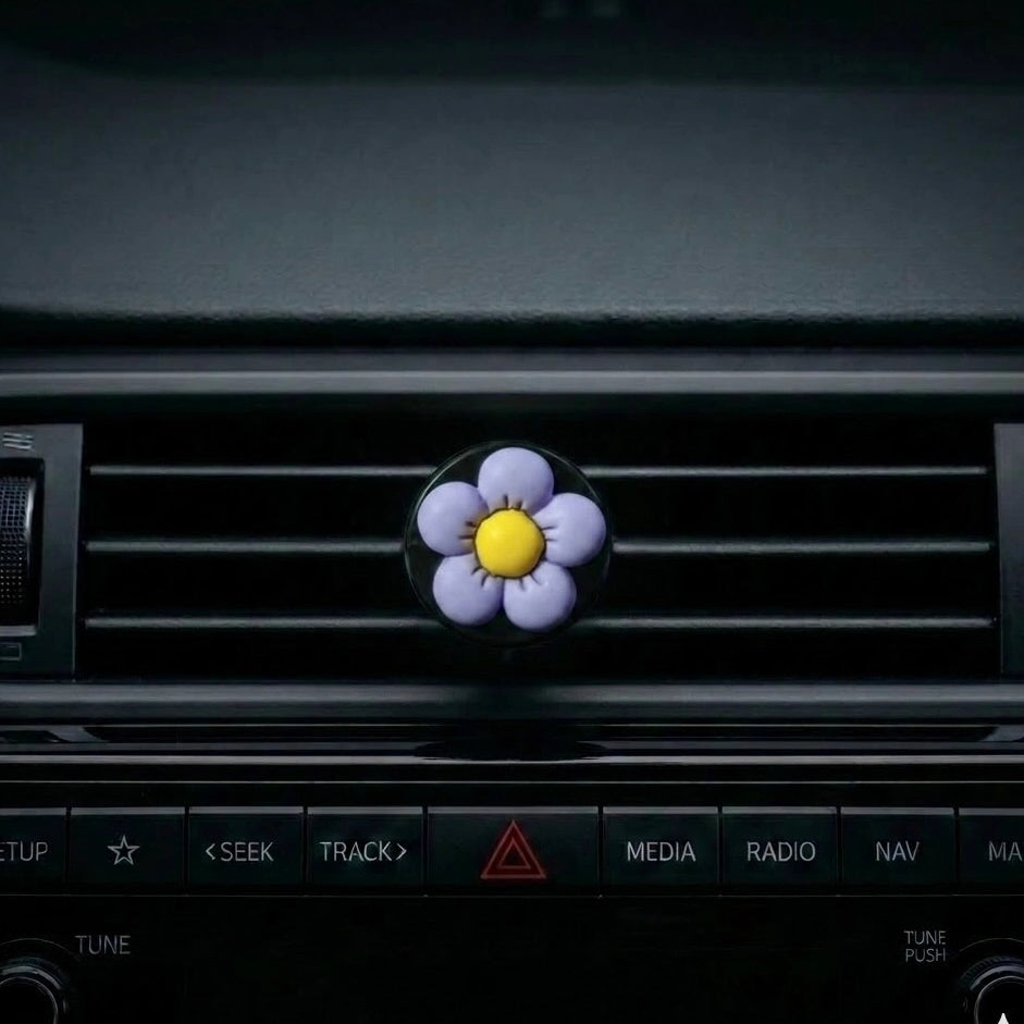 Purple flower car air freshener vent clip attached to car AC vent. A fun and fresh Car-Wah! car perfume for your daily commute.
