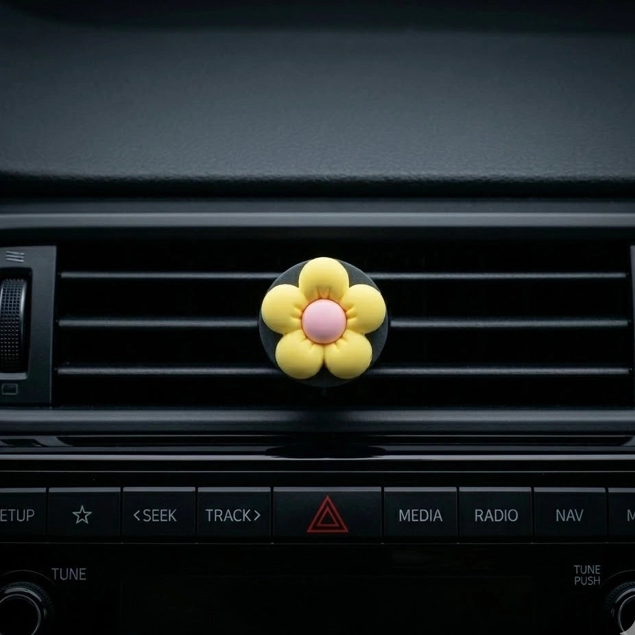 Yellow flower car air freshener vent clip perfume on car dashboard vent. A fun and fresh Car-Wah! car perfume for your daily commute.