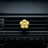 Yellow flower car air freshener vent clip perfume on car dashboard vent. A fun and fresh Car-Wah! car perfume for your daily commute.