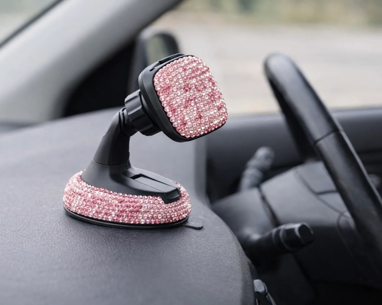 Pink rhinestone car phone holder mounted on dashboard. A bold car accessory by Car-Wah! to elevate your ride.