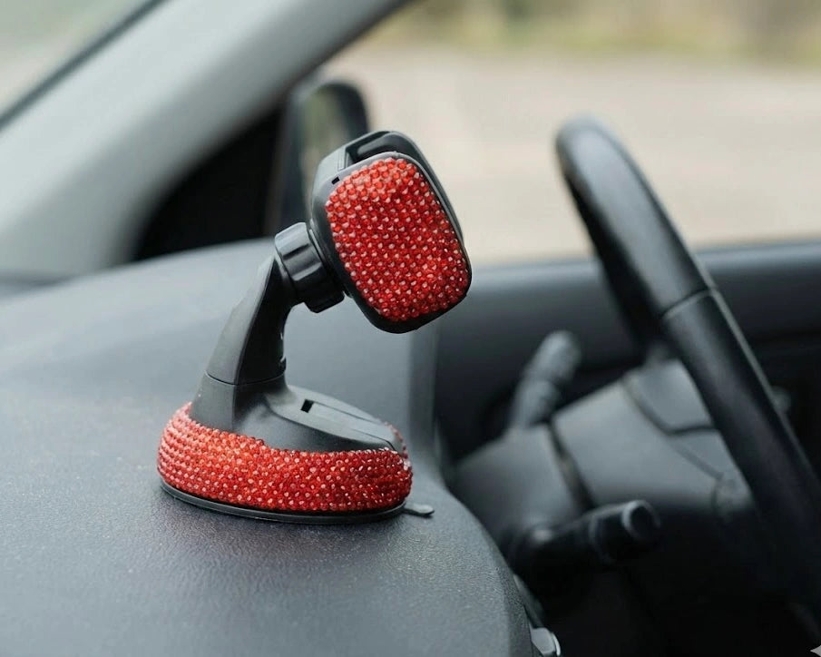 Red bling car mobile holder on car dashboard. A cheerful Car-Wah! upgrade for your daily drives.