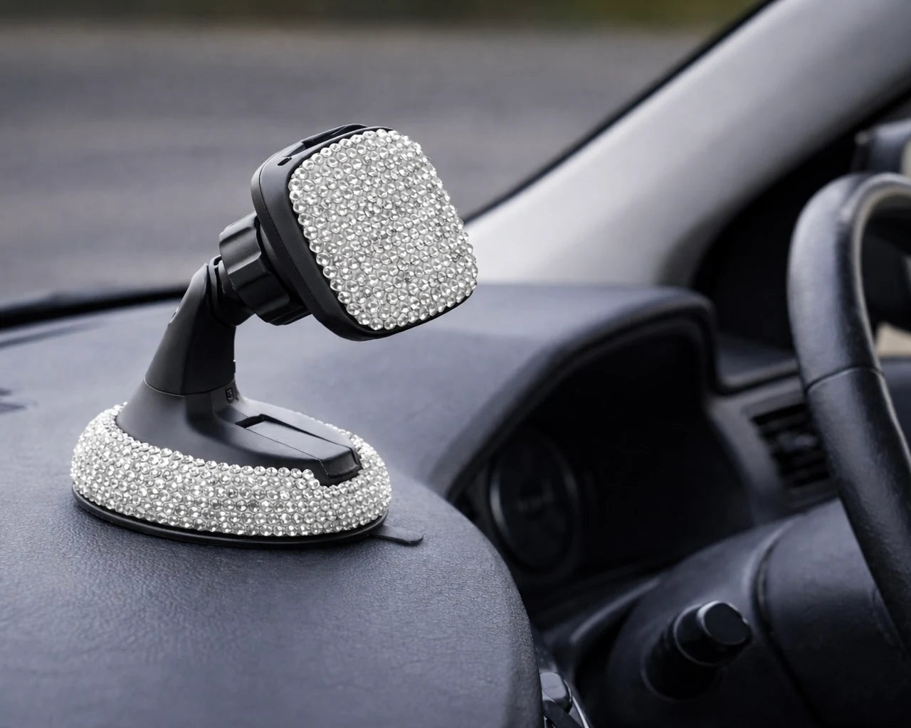 Silver rhinestone car phone holder mounted on dashboard, adding a fun pop to your car interior with Car-Wah!