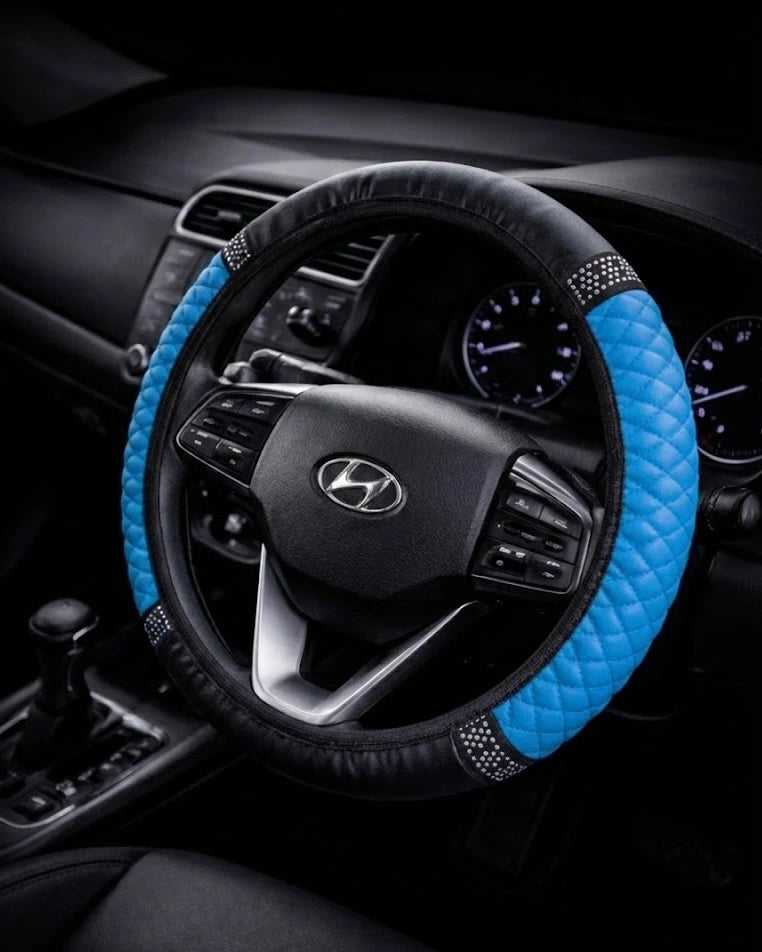 Blue PU leather steering wheel cover with anti-slip grip and rhinestone detailing installed on 38 cm car steering wheel.  A colourful Car-Wah! car decor upgrade for your daily drives.