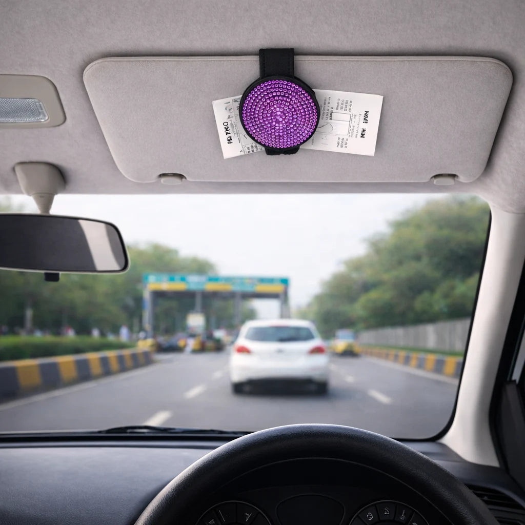 Purple rhinestone sunglasses holder on car visor storing parking tickets. A practical and aesthetic car accessory by  Car-Wah! to keep your world on wheels organized.