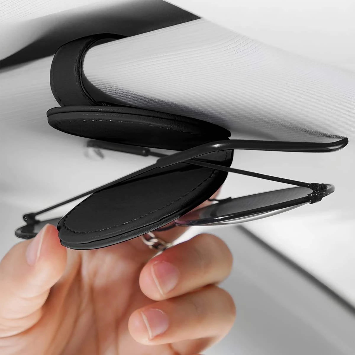 Magnetic visor clip holding sunglasses to prevent scratches in car. A practical and aesthetic car accessory by  Car-Wah! to keep your world on wheels organized.
