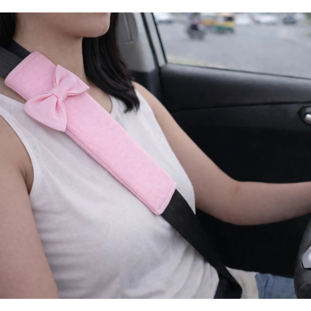 Pink seat belt pad worn during driving for neck comfort. A colourful and cozy driving comfort car accessories by Car-Wah!