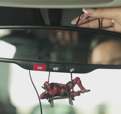 Anti-hero car dangler by Car-Wah! being set up in car