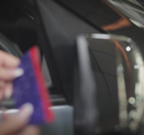 Person aligning ORVM cover onto car side mirror for stick-on installation, Pressing rhinestone ORVM cover firmly onto side mirror to secure adhesive